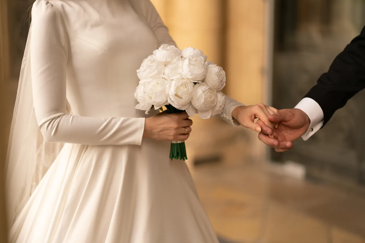 A couple hand in hand at their wedding